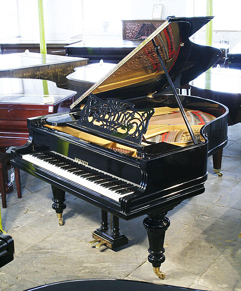 Restored, Berdux grand piano with a polished, black case and turned legs. Music desk features an art nouveau cut-out design with sinuous tendrils and the Berdux name