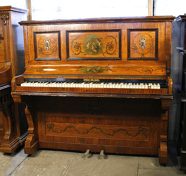 A Payne upright piano with a satinwood case,  hand-painted  with musical instruments, cherubs, flowers and swags