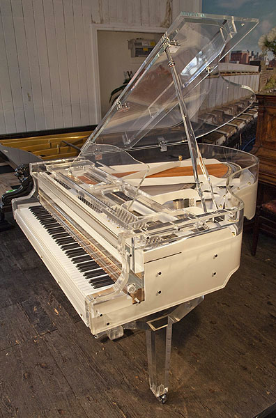 Brand new, Steinhoven grand piano with a transparent, acrylic case. Piano has an eighty-eight note keyboard and a thre-pedal lyre.