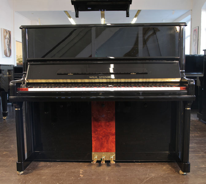 A Brand New Steinberg Model AT-32 upright piano with a black case, walnut panel and brass fittings. Piano features a carbon fibre action, eighty-eight note keyboard and three pedals
