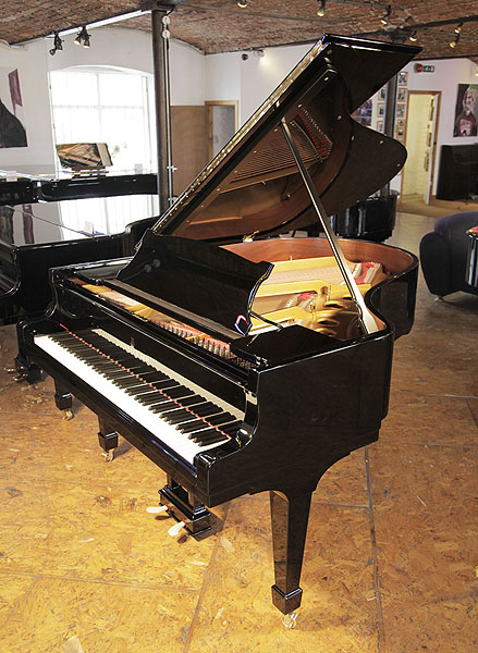 A rebuilt 1923, Steinway Model O grand piano with a black case and spade legs. Piano has an eighty-eight note keyboard and a two-pedal lyre.  