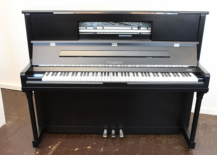 Brand new, Feurich Model 123 upright piano with a satin, black case, LED Lighting and chrome fittings. Piano features a high speed KAMM action that allows for extremely fast repetition. Piano has an eighty-eight note keyboard and three pedals. 