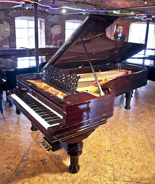Rebuilt, 1886, Steinway & Sons Model D concert grand piano with a rosewood case, filigree music desk and turned, fluted legs. Piano has an eighty-eight note keyboard and a three-pedal lyre.