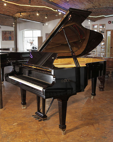 A 2006, Fazioli F212 grand piano with a black case and spade legs. Piano features a slow fall mechanism. Comes with velour concert stool. Piano has an eighty-eight note keyboard and a three pedal lyre. 