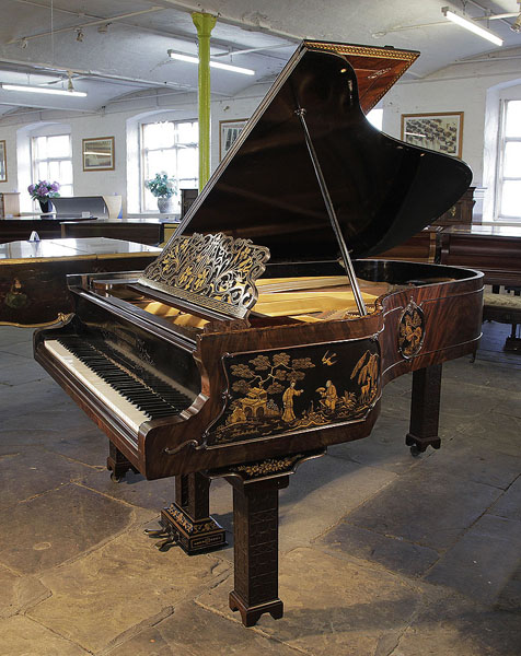 An 1899, Chinese Chippendale style, Schiedmayer grand piano for sale with a flame mahogany case and Malborough legs with applied fret carvings. Cabinet features Chinese scenes in embossed Japanning with gilt ornament. Piano has an eighty-five note keyboard and a two-pedal lyre.