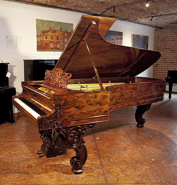 A stunning, 1877, Steinway & Sons Model D concert grand piano with an exquisite wood case and reverse scroll legs. Cabinet features piano cheeks carved with scrolling foliage. Piano has an eighty-eight note keyboard and a two-pedal lyre. 