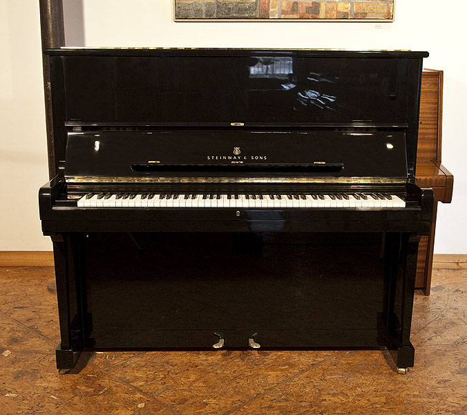 A 1985, Steinway Model K upright piano with a black case and brass fittings