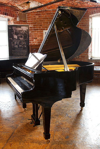 A rebuilt, 1951, Steinway Model S baby grand piano with a black case and spade legs. Piano has an eighty-eight note keyboard and a two-pedal lyre 