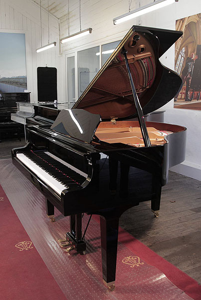 A 2012, Yamaha GB1 baby grand piano for sale with a black case and square, tapered legs. Piano lid has a slow fall mechanism. Piano has an eighty-eight note keyboard and a three-pedal lyre. 