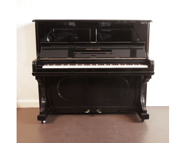 Antique, 1887, Steinway upright piano with a black case and indented front panels. Piano has an eighty-five note keyboard and two pedals.