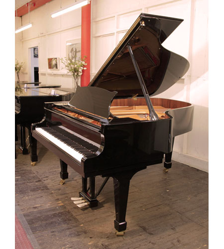 A 2018, Toyama TC-187 grand piano for sale with a black case and spade legs.  Piano has an eighty-eight note keyboard and a three-pedal piano lyre. 