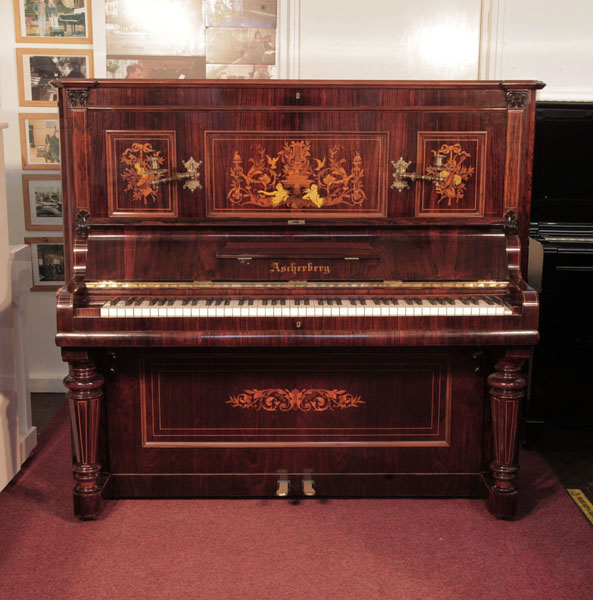 Restored, 1890, Ascherburg upright piano for sale with a rosewood case and satinwood stringing accents. Piano has turned, faceted legs with satinwood stringing accents. Piano has an eighty-five note keyboard and two pedals..