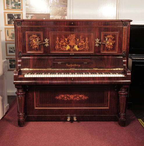 Restored, 1890, Ascherburg upright piano for sale with a rosewood case and turned, faceted legs. Cabinet features panels inlaid with a Neoclassical design in a variety of woods. Piano has an eighty-five note keyboard and two pedals.