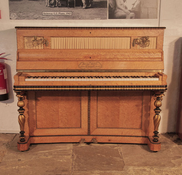 An 1860's, Chappell upright piano with a French style, bird's eye maple case. Cabinet features gilt and black accents.  The twisted, baluster leg design is accented with contrasting gilt and black wood. Piano has an eighty-five note keyboard.