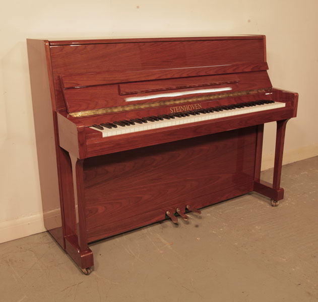 Reconditioned,  2000, Steinhoven  upright piano with a walnut case and polyester finish. Piano has an eighty-eight note keyboard and and three pedals.