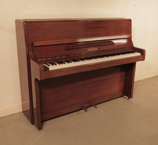 Reconditioned, 1970, Welmar  upright piano with a polished, mahogany case and brass fittings. Piano has an eighty-eight note keyboard and two pedals