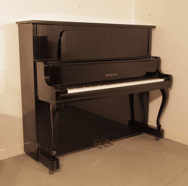 A 1980, Wieler U-5S upright piano with a black case, large music desk and cabriole legs. Piano has an eighty-eight note keyboard and three pedals