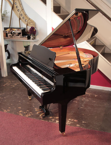 Reconditioned 2009, Yamaha GB1 baby grand piano with a black case and square, tapered legs. Piano has an eighty-eight note keyboard and a three-pedal lyre. 