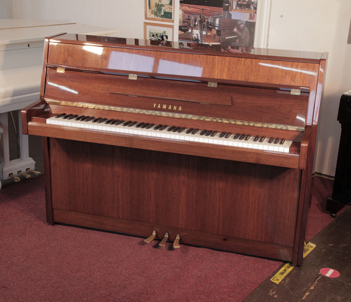 Reconditioned, 1987, Yamaha  M108 Upright piano for sale with a walnut gloss case and brass fittings. Piano has an eighty-eight note keyboard and three pedals. 