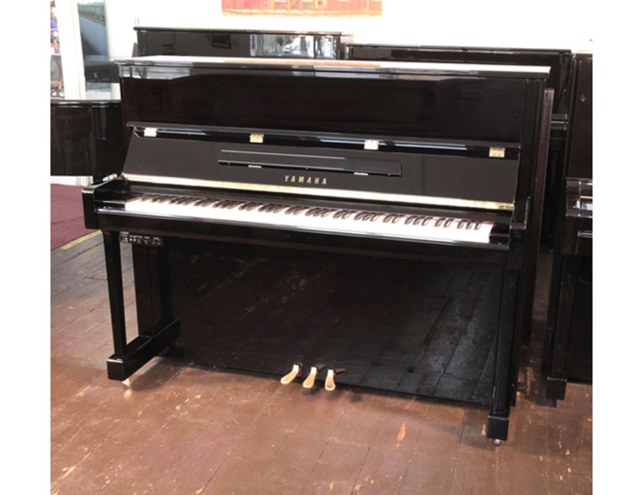 A 2020,Yamaha b3e PE-Silent upright piano with a black case and fitted Silent System. Piano has an eighty-eight note keyboard and three pedals. 