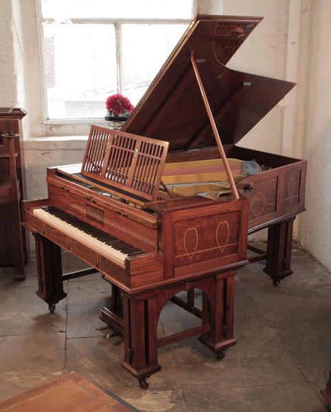 Arts and Crafts, Bechstein ModelI grand piano with a mahogany case and copper mounts. Cabinet inlaid with hearts, bellflowers and celtic knotwork.  Piano has vaulted arched, gate legs attached with a cross stretcher.  Piano has an eighty-five note keyboard and a two-pedal lyre.