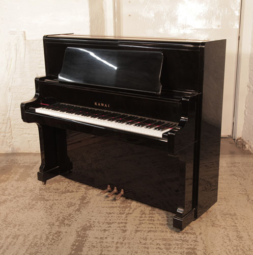 Piano for sale. A Kawai US-50 upright piano with a black case and polyester finish. Piano has an eighty-eight note keyboard and three pedals. 