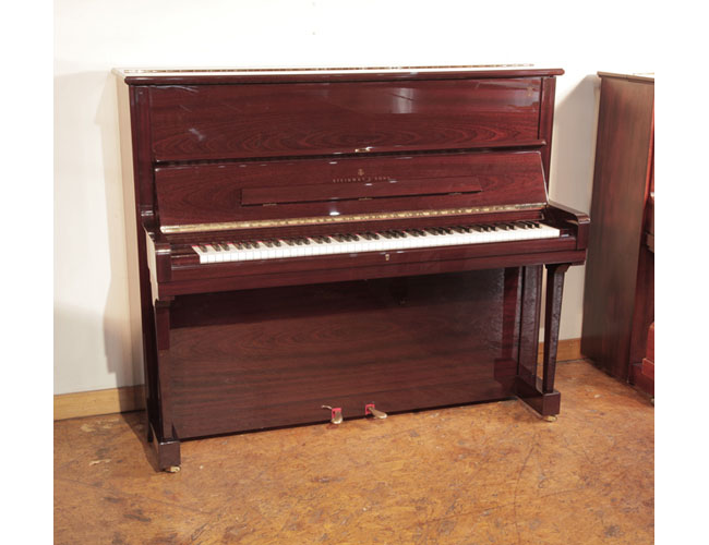 A 2009, Steinway model V upright piano with a mahogany gloss case. Piano has an eighty-eight note keyboard and two pedals . 