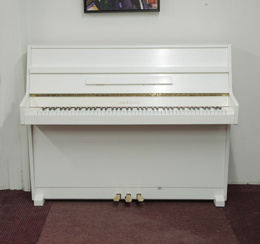 An Urk & Sons VU 110 upright piano with a white gloss case. Piano has an eighty-eight note keyboard and three pedals 
