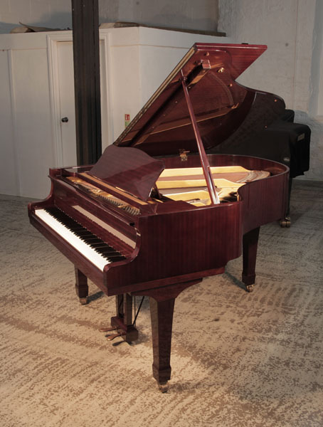 A Yamaha G2 grand piano with a mahogany case and spade legs. Piano has an eighty-eight note keyboard and a two-pedal lyre.  