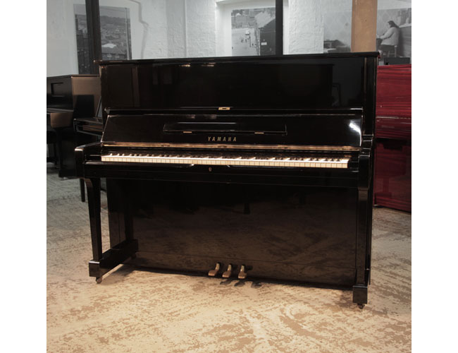 Reconditioned, 1973, Yamaha U1 upright piano with a black case and polyester finish. Piano has an eighty-eight note keyboard and three pedals.
