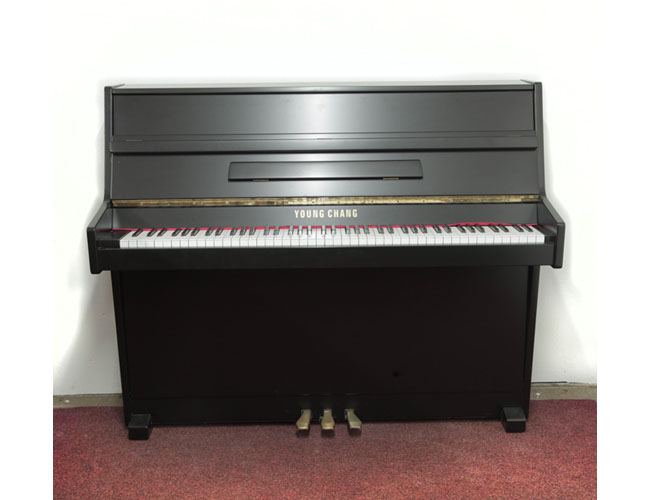 A 1988, Young Chang U-109 upright piano with a satin, black case and brass fittings . Piano has an eighty-five note keyboard and three pedals. 